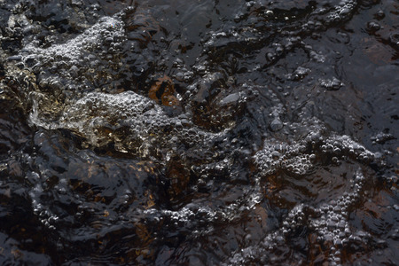 A raging stream of water in a swift stream.の写真素材