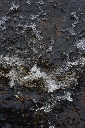 A raging stream of water in a swift stream.の写真素材