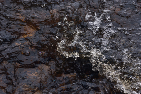 A raging stream of water in a swift stream.の写真素材