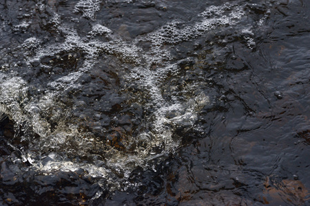 A raging stream of water in a swift stream.の写真素材