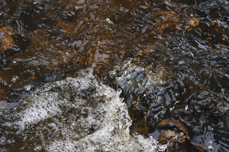 A raging stream of water in a swift stream.の写真素材