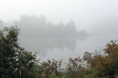 Early autumn morning. Dense fog envelops the surface of the river.の写真素材