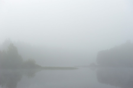 Early autumn morning. Dense fog envelops the surface of the river.の写真素材