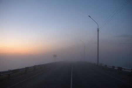 Midnight car track covered with fogの写真素材