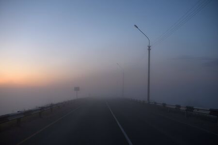 Midnight car track covered with fogの写真素材