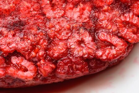 Food background. Freshly frozen raspberries, turned into a juicy piece of ice during freezing.