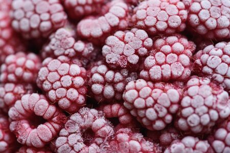 Food background. Freshly frozen raspberries, turned into a juicy piece of ice during freezing.