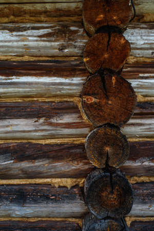 Aged, cracked and discolored logs of the building close up.の写真素材