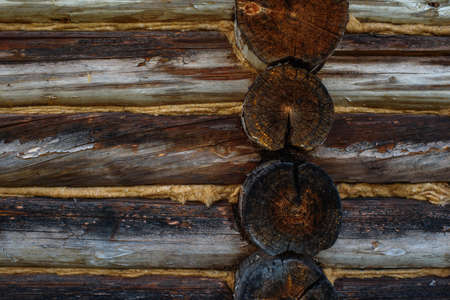 Aged, cracked and discolored logs of the building close up.の写真素材