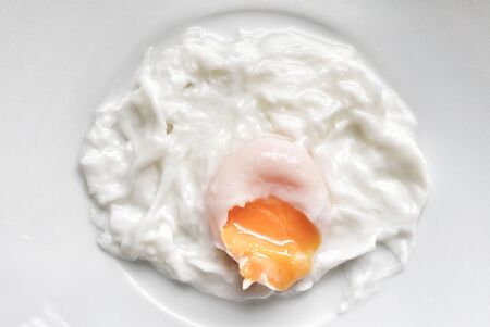 Top view fried egg in a white plate on  kitchen tableの写真素材