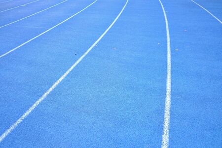 Close up blue running lane with white curves for background texture