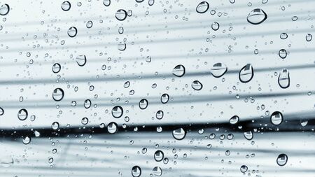 Blurred rain drops on car window with heavy rainy and  dramatic weather,messy electricity lines backgroundの写真素材
