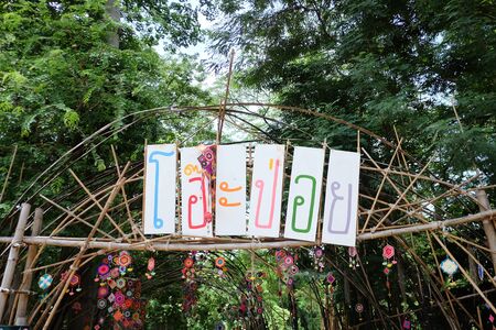 A signboard of Oh Poi Market in Thai language on a bamboo pole,a famous local market in...
