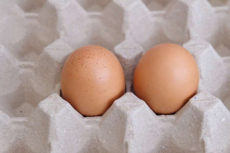 In selective focus two fresh eggs in a paper box and selling at the food market