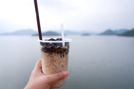 Iced coffee with milk in plastic cup on the nature background.の写真素材