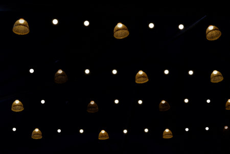 In Selective focus a group of bamboo lightbulbs hanging in a round and shinning in the dark of the nightの写真素材