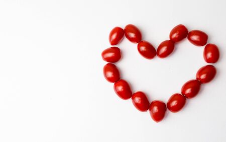 Heart shaped tomatoes on a white backgroundの写真素材