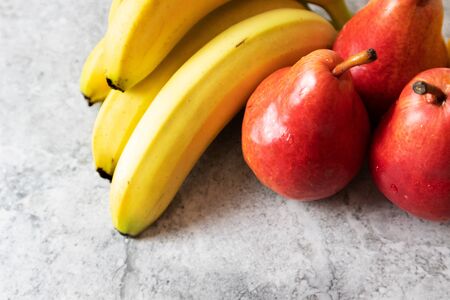 Bananas and red pears on a light backgroundの写真素材