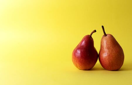 Two red pears on an yellow backgroundの写真素材