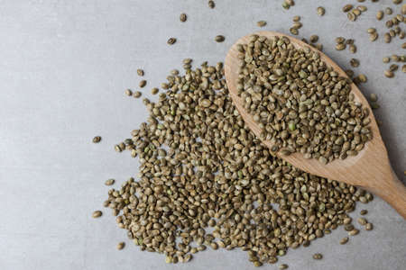 Wooden spoon with hemp seeds on a concrete surface. Food background. Horizontal orientation.の写真素材