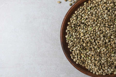 There is a clay bowl with hemp seeds on the concrete surface.の写真素材