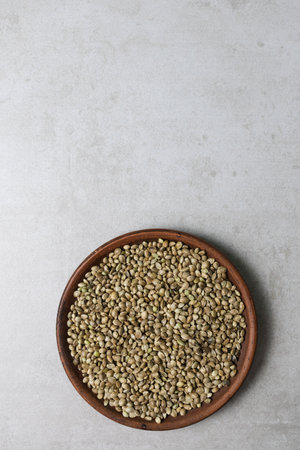 There is a clay bowl with hemp seeds on the concrete surface.の写真素材