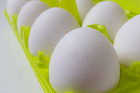 White eggs in green plastic packaging. Close-up.の写真素材