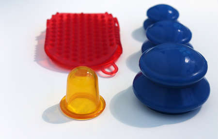 Yellow and blue vacuum massage jars and red silicone massage brush on a white background.の写真素材