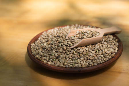 Hemp seeds in a clay dish. Wood backgroundの写真素材