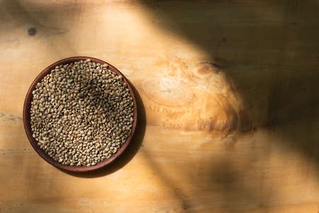 Hemp seeds in a clay dish. Wood background with copyspase.の写真素材