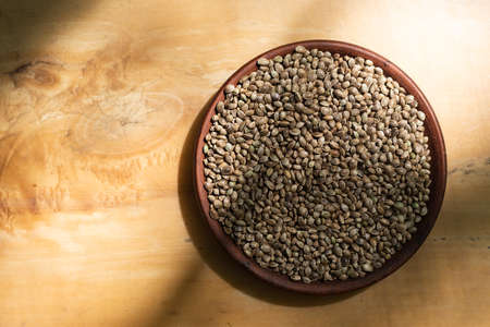 Hemp seeds in a clay dish. Wood backgroundの写真素材