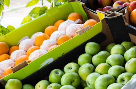 Ripe apples and oranges on the counter in a grocery storeの写真素材