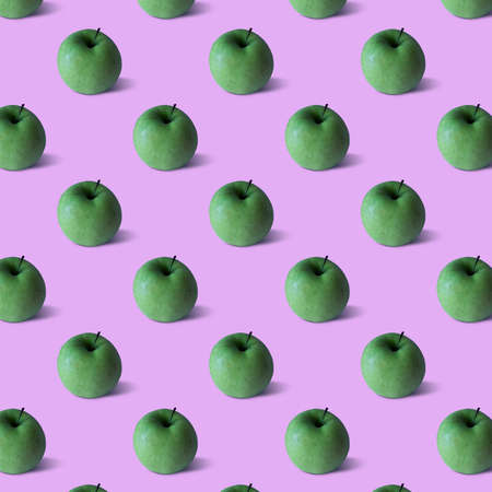 Pattern. Green apple on neon lilac color backgroundの写真素材