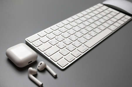 Wireless keyboard, mouse and headphones in white on a gray background. English-Russian letter layout.の写真素材
