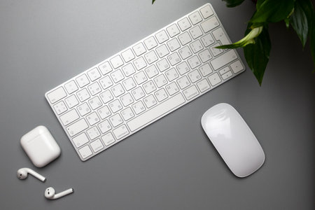 Wireless keyboard, mouse and headphones in white on a gray background. English-Russian letter layout.の写真素材