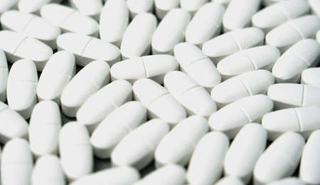 Patern of white calcium capsules with vitamin D on a gray background. Medical background.の写真素材