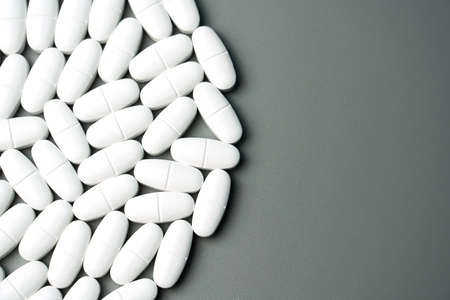 Calcium capsules with vitamin D on a gray background in the shape of a circle with a place for your text. Medical background.の写真素材