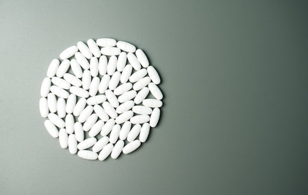 Calcium capsules with vitamin D on a gray background in the shape of a circle with a place for your text. Medical background.の写真素材
