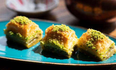 Turkish baklava with pistachios on a turquoise plate.の写真素材