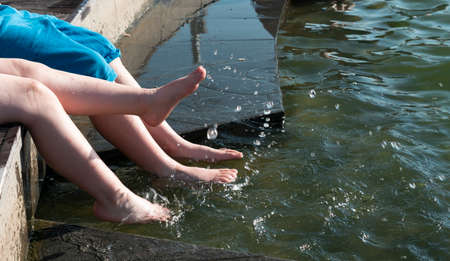 Childrens feet splash in the water of the fountainの写真素材