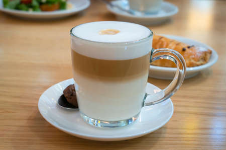 There is a mug of latte on the tableの写真素材