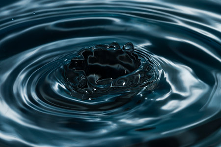 Circles on the water from a fallen drop of water. dark blue background. high quality photoの写真素材