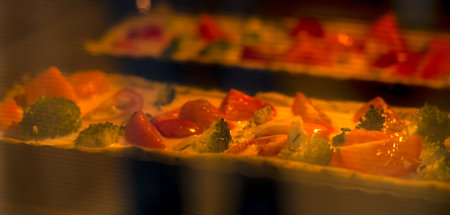 Quiche with salmon, broccoli and tomatoes is baked in the oven. Cooking a pie. high quality photoの写真素材