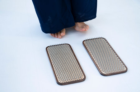 The girl is preparing to stand on the board with nails. Nailing on boards of sadhus. high quality photoの写真素材