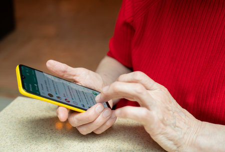 The phone is in the hands of an elderly woman of retirement age. Smartphone use by the elderly. high quality photoの写真素材