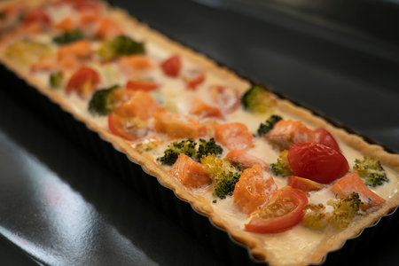 Ready-made quiche with salmon, broccoli and tomatoes. Cooking a pie. high quality photoの写真素材
