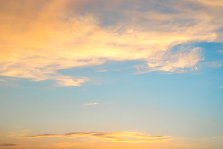 Beautiful orange clouds in the blue sky. Background for screen saver, wallpaper, cover. high quality photoの写真素材