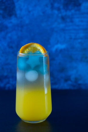 Non-alcoholic cocktail made from orange juice and blue Thai tea. Cubes in the form of stars. Summer refreshing drink. high quality photoの写真素材