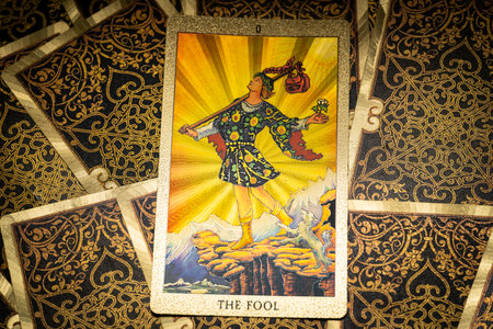 Gold embossed tarot cards on the table. The Major Arcana card The Fool lies facing the viewer. high quality photoの写真素材