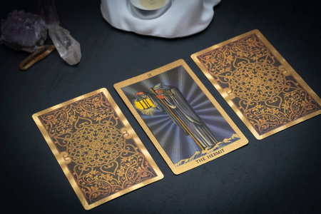 Gold embossed tarot cards on the table. The Major Arcana card The Hermit lies facing the viewer. high quality photoの写真素材